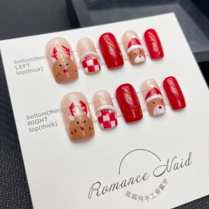 Handmade Christmas press-on nails with cute hand-painted reindeer and festive red designs