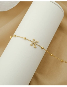 Detail of gold K-letter pendant with zircon stones on a beaded stainless steel chain