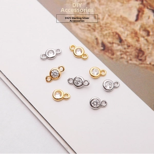 Macro shot of S925 sterling silver connector charms with clear cubic zirconia in gold and silver