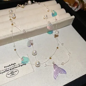 Double-layer pearl necklace with iridescent shell sequins and a purple mermaid tail pendant