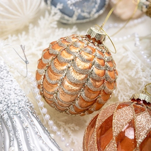 Luxurious orange-gold Christmas glass ornaments with scales pattern and sparkling gold glitter