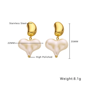 Detailed view of polished gold stainless steel earrings with cream heart pendant charms