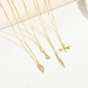 Minimalist gold dragonfly, wing, and arrow pendant necklaces on a clean white background