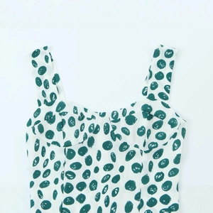 Women's slim white tank dress with green polka dot print and sexy side slit hemline