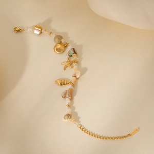 Macro shot of stainless steel necklace with seashell, starfish charms and beads detail