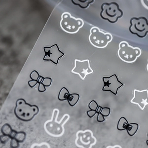 Stereo matte cartoon nail stickers with bear and bow designs on grey background