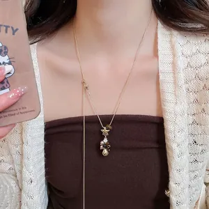 Collier avec pendentif étoile en œil de tigre et perle sur chaîne dorée porté