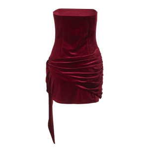 Detailed close-up of dark red velvet mini dress with elegant side ruffles and draping
