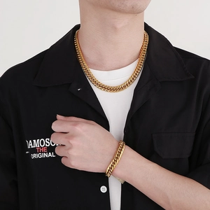 Men's thick gold Cuban link chain necklace and bracelet set worn on model