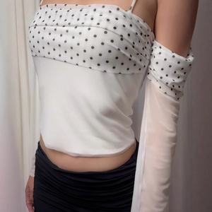 Detail of off-shoulder mesh top with black polka dots and matching sleeve covers