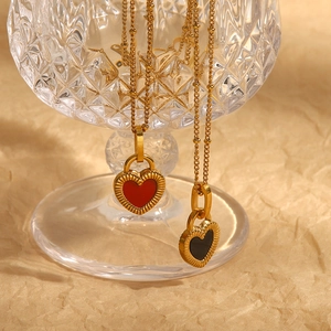 Colliers vintage français avec pendentifs cœur rouge et noir sur bord de verre