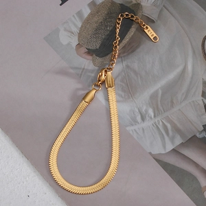 Detail of 18K gold plated snake chain bracelet with lobster clasp on a fashion magazine