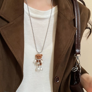 Detail of flocked brown teddy bear pendant with pearl accents on a silver beaded chain
