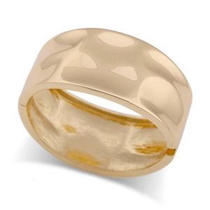 Close-up of golden wide cuff bracelet with hammered texture and hinge closure detail