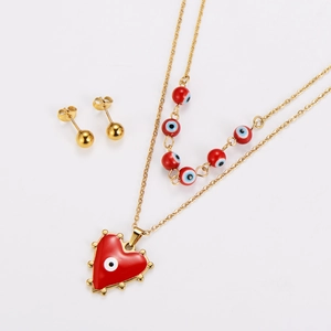 Detail of gold necklace with red enamel evil eye heart pendant and matching stud earrings