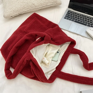 Macro detail of plush burgundy tote bag with white lining and interior zipper pocket