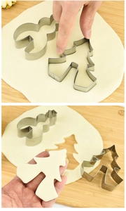 Detail showing stainless steel reindeer and Christmas tree cookie cutters on dough