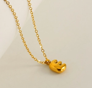 Close-up of golden 18K gold plated letter E bubble pendant necklace for women