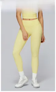 Detailed close-up of high-waisted yoga leggings and top set in goose yellow fabric