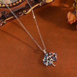 Detail of silver Tree of Life pendant featuring colorful stones and stainless steel chain