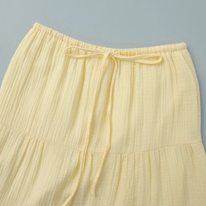 Detailed view of yellow cotton skirt with elastic drawstring waist and wrinkled texture