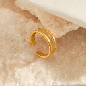 Minimalist double layer gold plated stainless steel open ring on beige stone texture