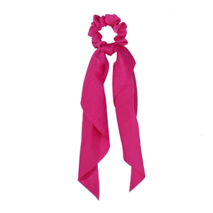 Detailed view of a soft pink satin ponytail scrunchie with long streaming ribbons