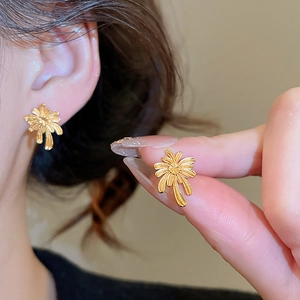 Close-up of gold plated palm tree stud earrings with elegant matte texture finish