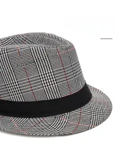 Macro shot of the black and white plaid fabric and wide band on the classic fedora hat