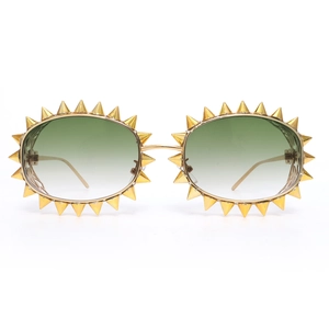Detail einer goldenen Oval-Sonnenbrille mit Metall-Spikes und grünen Verlaufsgläsern