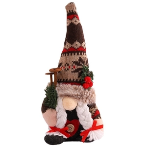 Christmas gnome doll with a red knitted snowflake hat and white braids on white background