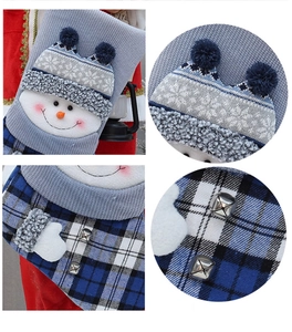 Détail d'une chaussette de Noël en tricot gris avec motif bonhomme de neige et pompons