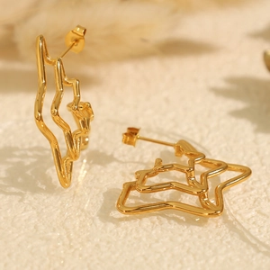 Unique textured gold spider web star earrings in an elegant minimalist aesthetic