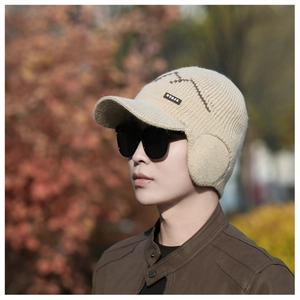 Detail of beige winter knit beanie with warm ear flaps and sturdy brim in outdoor setting
