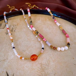 Close-up of gold plated agate beaded necklace on a vintage calligraphy plate decor