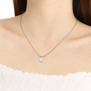 Silver stainless steel necklace with rectangular letter B pendant worn by a model