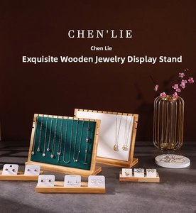 Detailed view of bamboo wood jewelry display stands with green velvet and white backboards