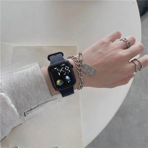 Close-up of a blue silicone sports watch with silver chain bracelet and ring