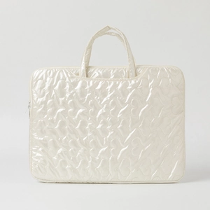 Detail of pearlescent laptop bag featuring heart-shaped quilting and smooth zipper