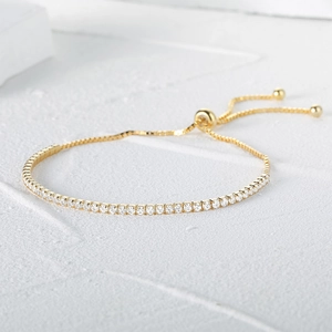 Detail of adjustable golden tennis bracelet with round cubic zirconia and slider clasp
