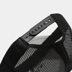 Dettaglio del cappello trucker nero in rete con chiusura snapback regolabile in plastica