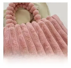 Close-up of pink faux fur tote bag with plush spherical handles and vertical pleated texture
