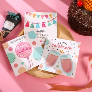 Detailed view of assorted birthday greeting cards with balloons and champagne on a wood tray