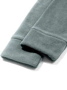 Dettaglio ravvicinato del polsino elastico e del tessuto in pile grigio-blu della felpa
