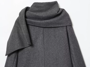 Detailed close-up of dark grey wool coat featuring unique layered scarf collar design