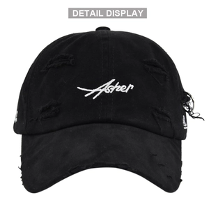 Detail view of distressed black baseball cap with white Asher embroidery and metal rings