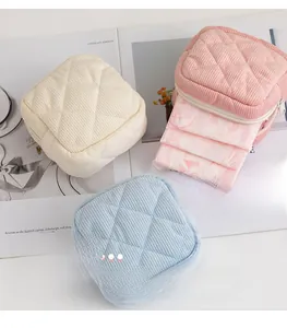 Three corduroy sanitary napkin bags in macaron colors with quilted diamond pattern