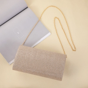 Detail of champagne glitter envelope clutch bag with gold chain and flap closure