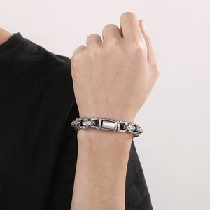 Detail of vintage silver punk bracelet with hammered texture on a male model wrist