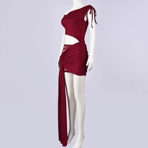 Détail d'une robe en tricot bordeaux à une épaule avec découpe à la taille et ruban